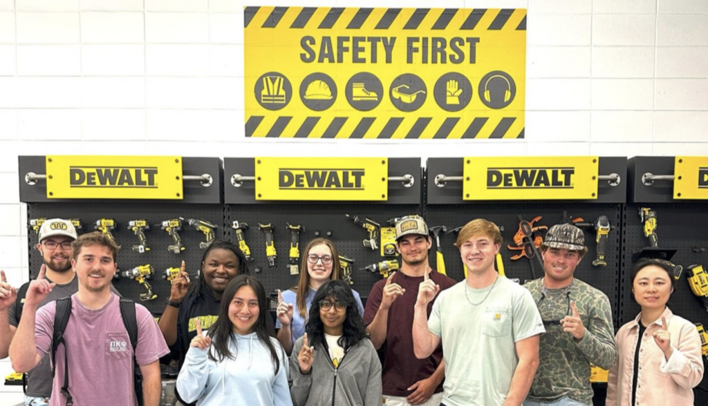 group photos of students and Dr. Fan Zhang in front of a tool display and yellow signs that read "DeWalt" and "Safety First"